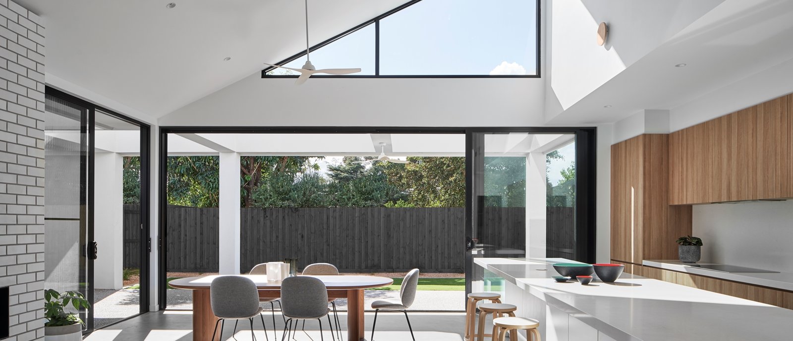 modern kitchen and dinning area  with thermares windows and doors with minimalist furniture allowing natural light in opening to  the backyard