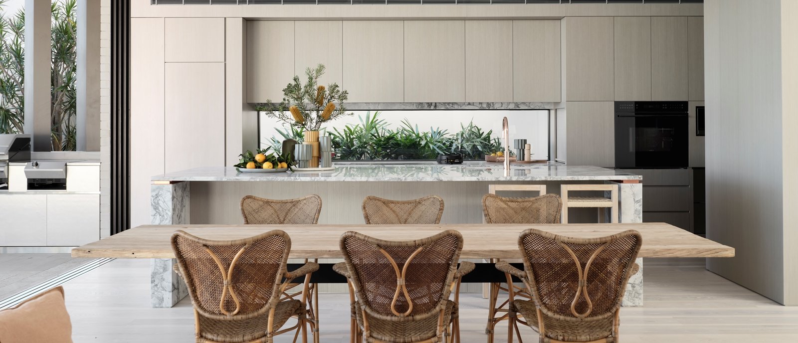 rustic minimalist kitchen and dinning area  ratan chairs and marble kitchen island